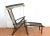 An antique, early 20th-century folding wood deck chair (or lawn chair, beach chair, or lounge chair), with colorful green,...