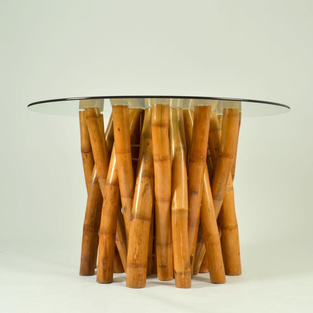 Sculptural 1950's bamboo dining table is formed in two parts first a cluster of large bamboo legs in the form of a circle...
