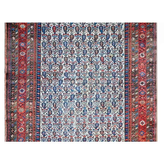 A wonderful early 20th century Persian Nehband rug with an all-over paisley and stylized floral pattern woven in myriad...