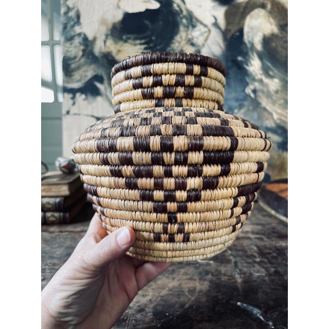lovely handmade, coiled basket, presents with a deep chocolate figural design that alternates between a geometric pattern....