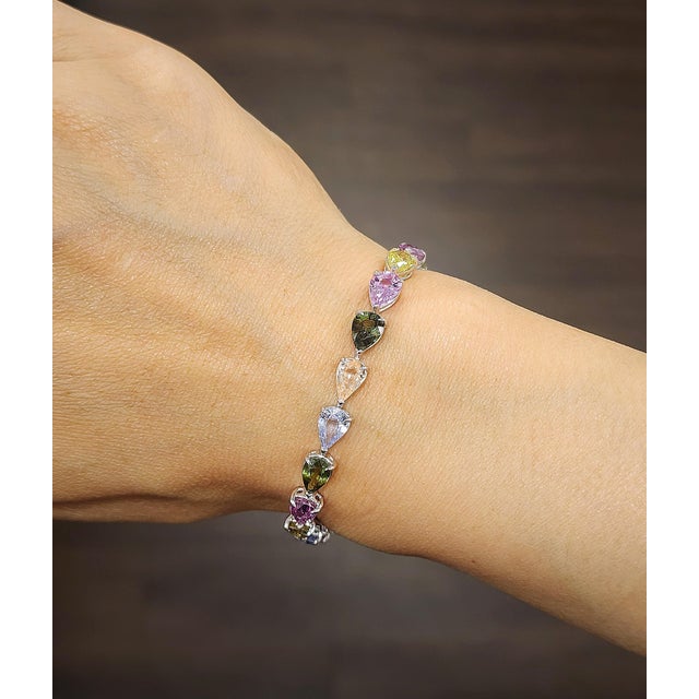 This modern rainbow sapphire bracelet is a vibrant expression of color and sophistication, beautifully crafted in...