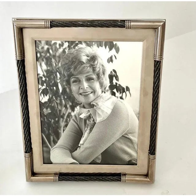 A silver plate frame for 8 x 10 photos. The piece is unique in that it uses woven twisted wire as an accent and it looks...