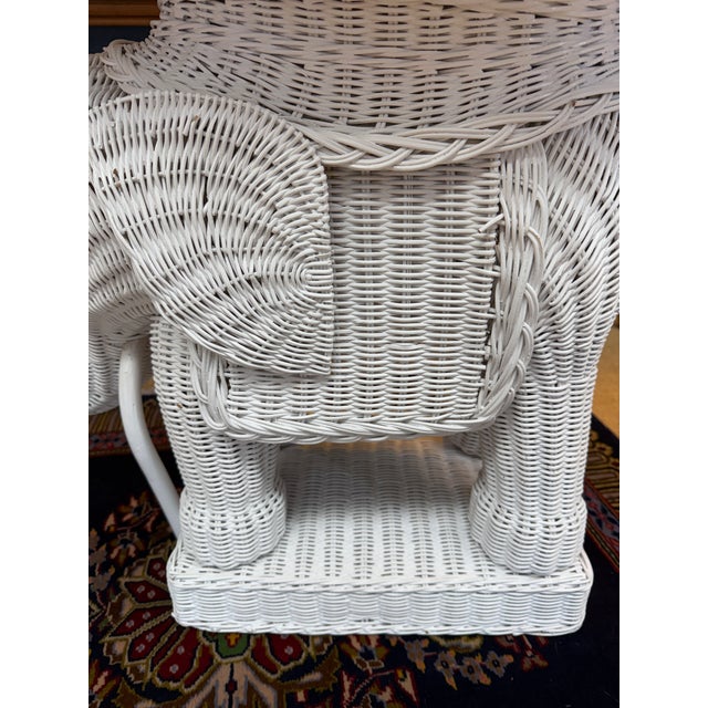 This is an adorable wicker elephant likely. from the 1980's that has his trunk up for good luck! It has a removable tray...