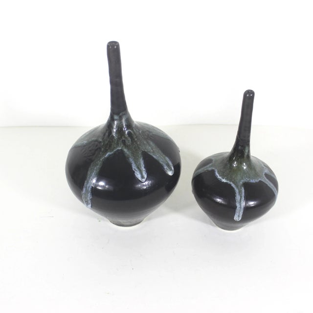 Stunning pair of vintage studio pottery bottle neck bud vase. Studio stamp on the bottom. The base glaze is black and has...