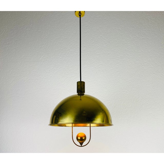 Extraordinary polished brass pendant lamp designed by Florian Schulz and made in Germany in the 1970s. It is fascinating...