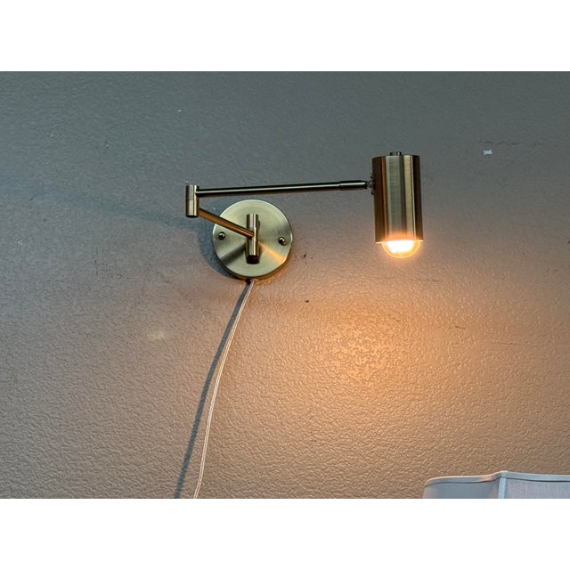 Design Plus Gallery presents a Modern Swing Arm Wall Lamp. The circular wall plate supports two articulated arms that...