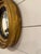 This antique English convex mirror is styled in the Regency fashion with a signature gilt gold frame and ebonized black...