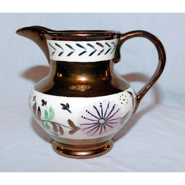 Gorgeous complimentary set of copper lustre creamers with bands of pink flowers. Larger creamer measures 3.75" x 4.25" x...