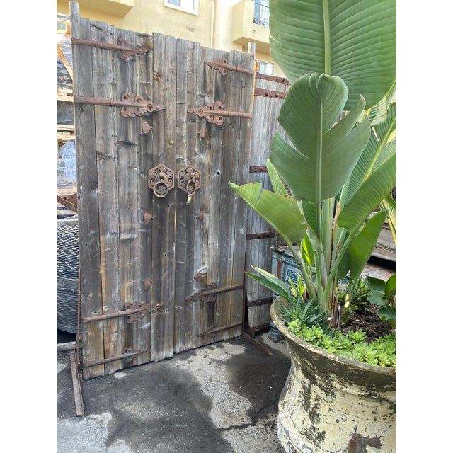 Old Mongolian wood door or gate. Original iron ring handles and iron strap details. Beautiful aged pine wood with signs of...