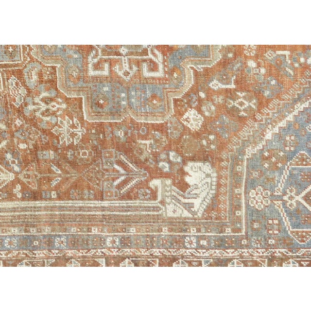 This semi-antique Persian Shiraz rug, measuring 7'1" x 10', is handwoven in the Shiraz region of Southern Iran. Persian...