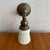 This early 20th-century industrial wall sconce features a brass pipe arm paired with an elegant frosted pressed glass...