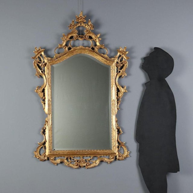Barocchetto style mirror crafted from carved and gilded wood, dating back to early 20th century Italy. The design features...