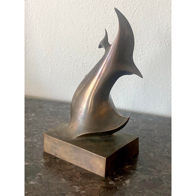 This nicely stylized seagull and wave sculpture, with its crescent body, arched wing and simplified head, reflects the...