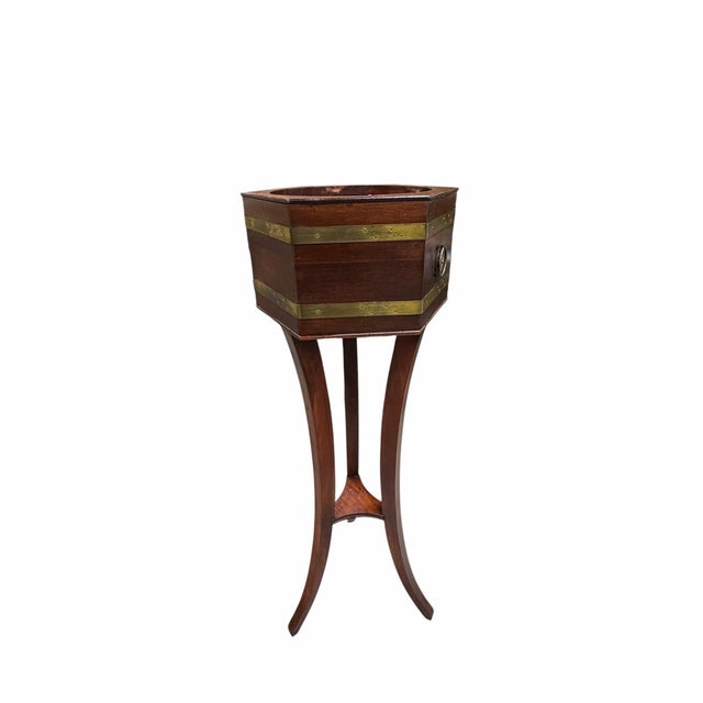 Mid century Butler furniture brass banded mahogany hexagon tripod plant stand with liner. The star center knocker handles...