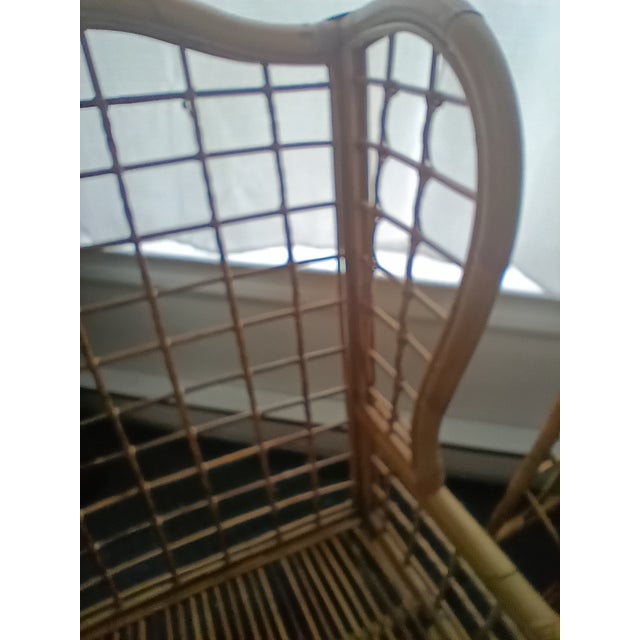 Rare find. Chippendale influence Rattan Wingback chair with matching ottoman. Lovely arm detail arched upper back and...