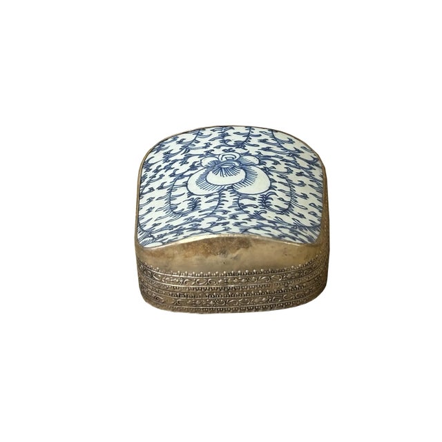 This is a handmade pewter box in an irregular shape with an old white base blue oriental scroll leaf graphic porcelain...