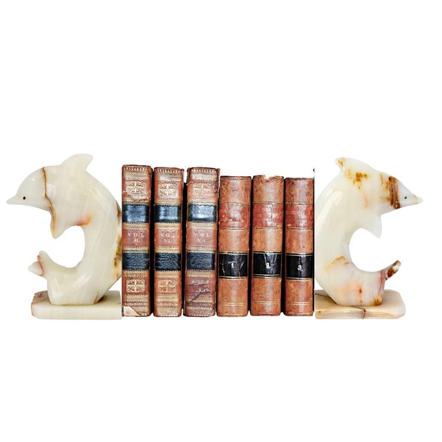 Midcentury Italian dolphin bookends carved from solid alabaster, showcasing beautiful natural veining in soft cream, warm...
