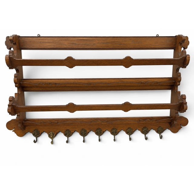 Substantial wall-mounted coat and hat rack in the Arts & Crafts tradition, crafted of hardwood with a warm honey-brown...
