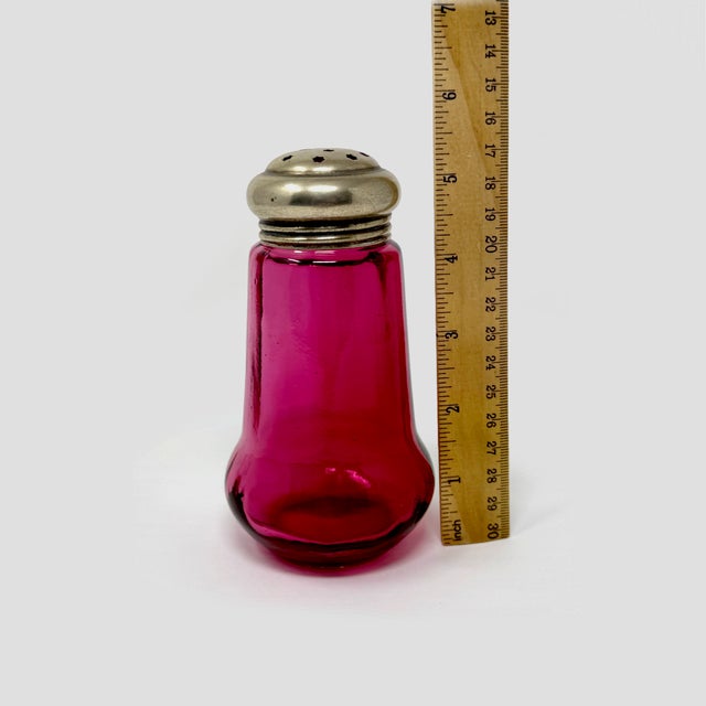 Bring timeless Victorian elegance to your collection with this beautiful Antique Cranberry Glass Sugar Shaker. Measuring...