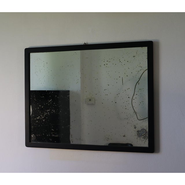 A beautiful, generously sized mirror with a simple, elegant ebonized wood frame. The reflective surface shows some signs...