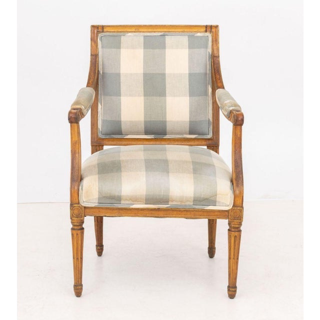 Louis XVI Style Walnut Arm Chair, with blue and white gingham upholstery. 34" H x 23" W x 19" D; seat: 18.5" H....