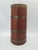 An elegant umbrella stand made of solid wood in a warm mahogany tone, accented with decorative brass bands. The form draws...