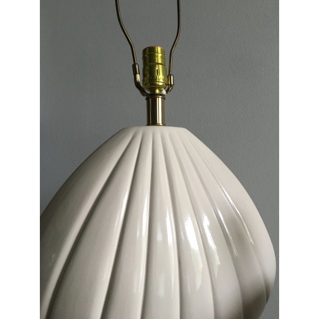 Pair of vintage ceramic lamps. Warm ivory color with a scalloped wood base.