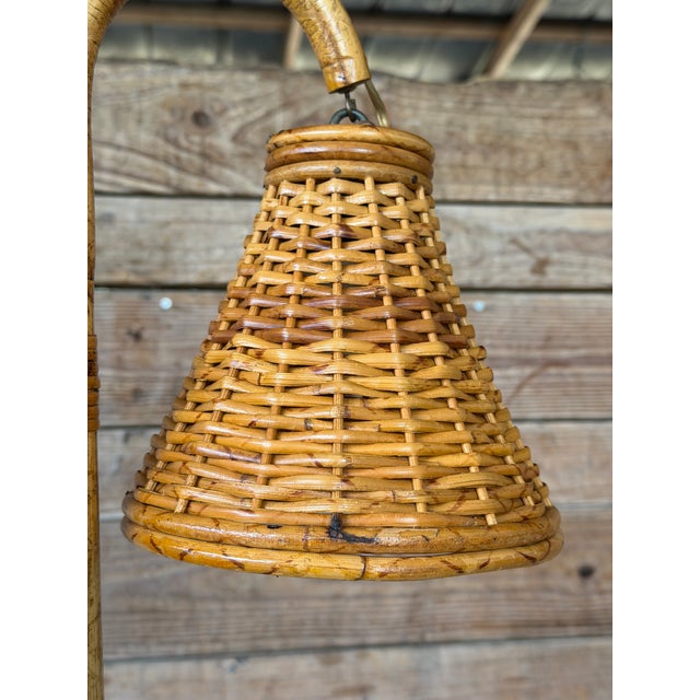 An exceptional and increasingly rare Mid-20th Century French rattan table lamp featuring a sculptural double swan-neck...