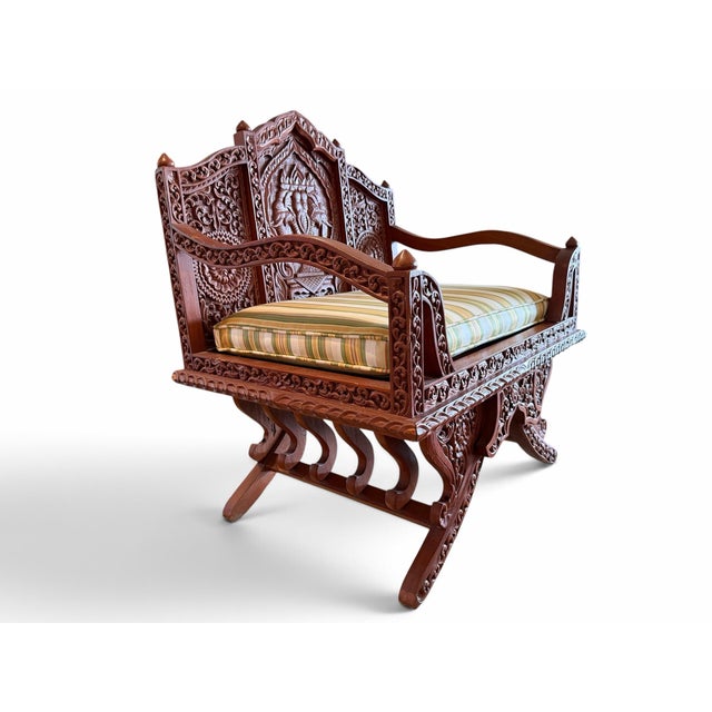 Make a majestic statement with this extraordinary vintage hand-carved teak wood master chair or mini-settee. Featuring a...