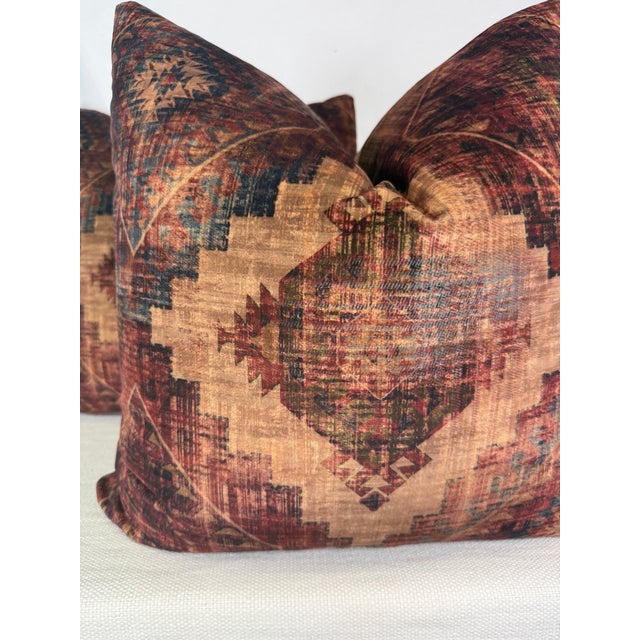 Custom pair of 22" pillows covered in an ikat printed velvet in wine and navy. These pillows have tapered corners to...