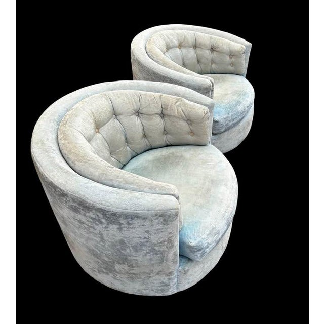 A pair of barrel-back swivel lounge chairs, circa 1970s, in the manner of Milo Baughman. Wraparound silhouette with low...