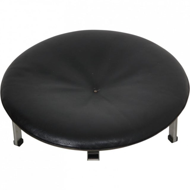Poul Kjærholm PK33 stool upholstered in black aura leather, and with a frame of chrome spring steel. The chair is from...