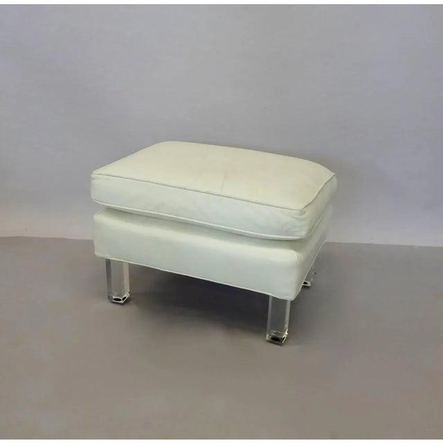 High style white leather ottoman on Lucite legs. Very well made. Leather shows patina more than age. Wrinkles in the...