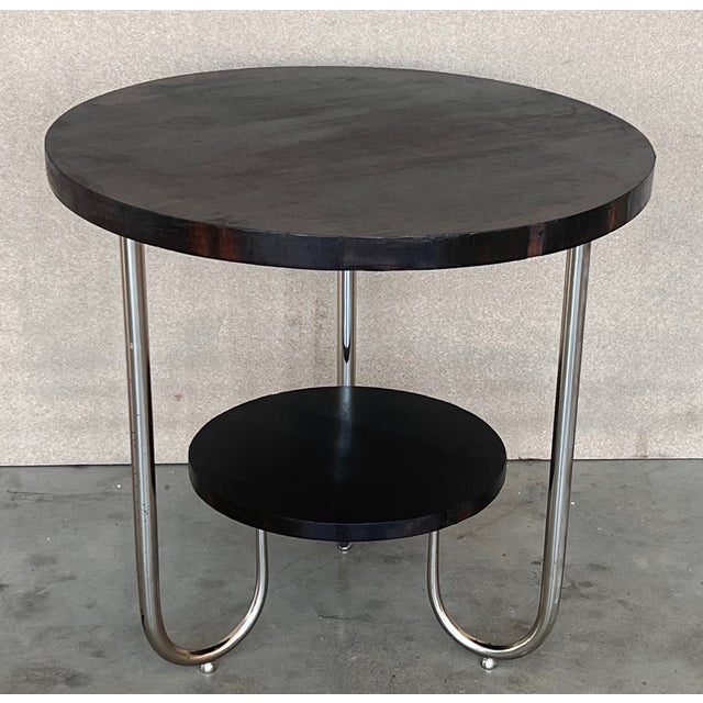 A fine French Art Deco two-tiered mahogany gueridon table supported by three tubular chromed . Height to the low shelve :...