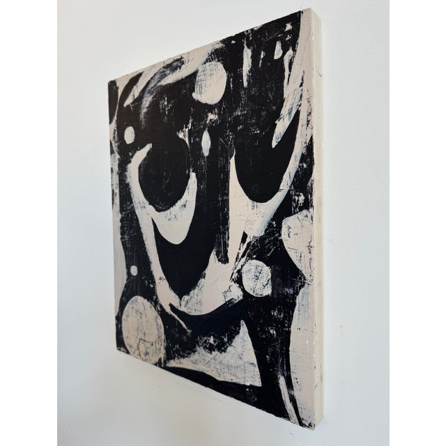 This abstract monochrome painting explores the interplay of black and white through bold, gestural brushstrokes and...