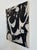This abstract monochrome painting explores the interplay of black and white through bold, gestural brushstrokes and...