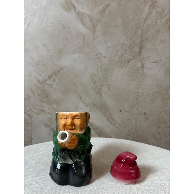 Charming and unusual ceramic teapot depicting a kneeling dwarf wearing his characteristic red cap. German manufacturer...