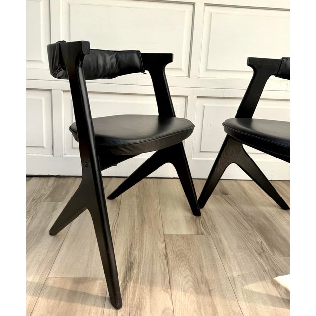 Here is a striking set of four Tom Dixon “Slab” dining chairs featuring sculptural black stained wood frames with black...