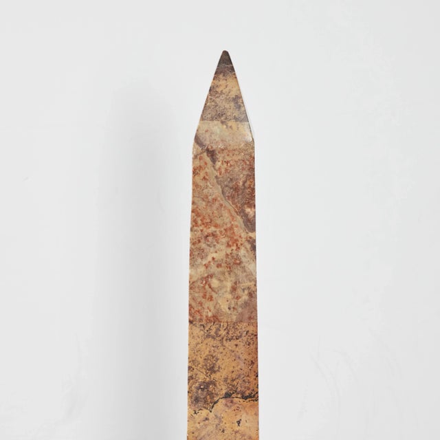 A hand carved, beautifully veined solid, polished marble obelisk mounted on a polished brass base.