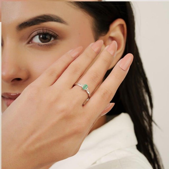 Featuring a 3×5 mm octagon-cut emerald gemstone weighing 0.28 carat, accented with diamonds weighing 0.12 carats, this 925...