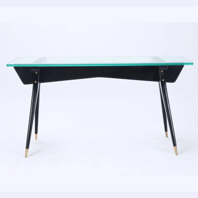 An ebonized wood glass top console/sofa table/desk with brass details. C 1950 in the manner of Ico Parisi.