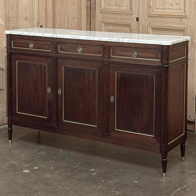 This refined French Louis XVI mahogany buffet with Carrara marble top makes a handsome and enduring addition to any...