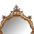 A beautifully carved Venetian style giltwood wall mirror featuring an elegant Rococo-inspired silhouette with flowing...