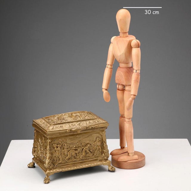 A bronze casket, embossed and chiseled throughout, decorated with scenes of farm work. Frames with leafy scrolls and...