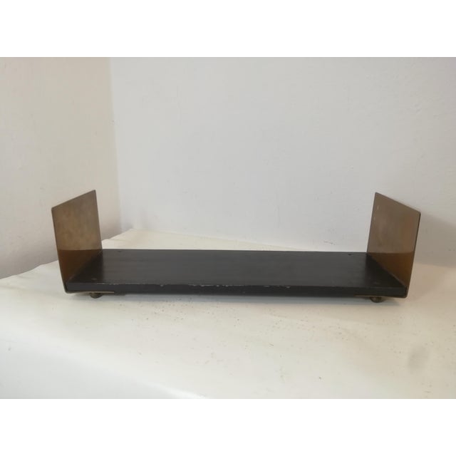 Beautiful table-top bookcase in varnished wood and thick, patina-finished brass. Original round brass feet. A highly...