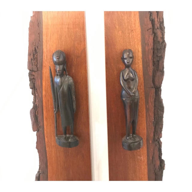 A pair of exotic hard wood panels with hand carved wood tribal male and female figures. Each panel with three hand...