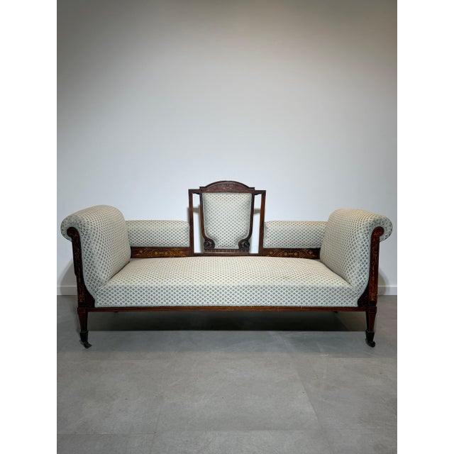 Elegant Edwardian period settee crafted in richly figured mahogany with exquisite satinwood and boxwood inlay decoration....