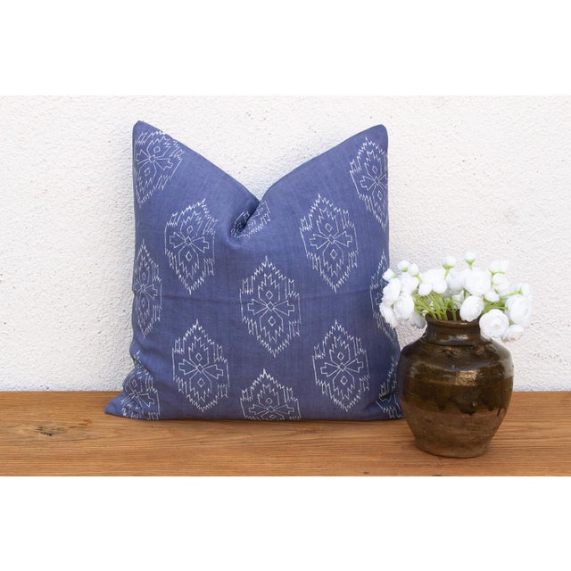 A repeating diamond medallion in pale ink covers the full face of this pillow, hand block-printed on deep indigo-blue...