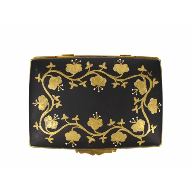 Elegant Limoges porcelain box with hand-painted gold floral design and brass frame. A timeless piece for storage or...
