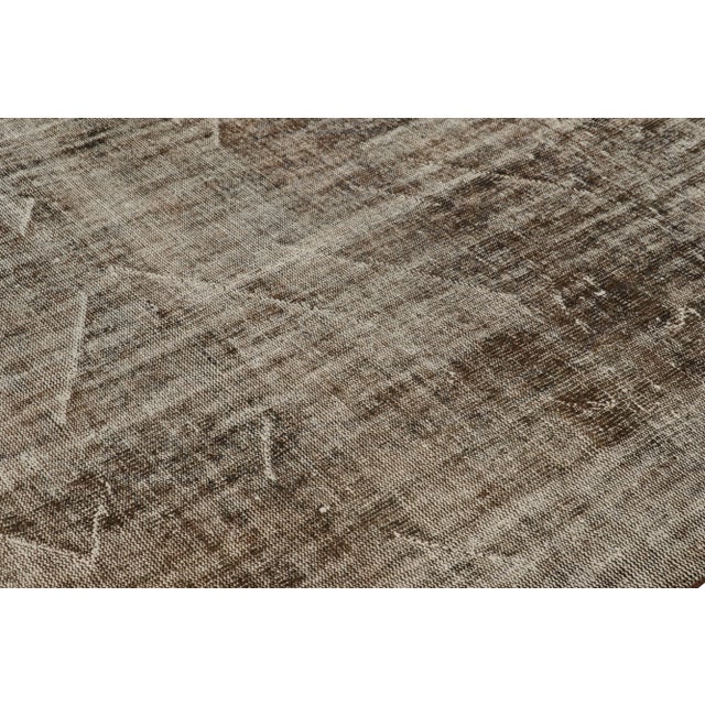 Hand-knotted in wool, this 6x9 vintage Turkish rug is from that collection of mid-century rugs with antique washes giving...